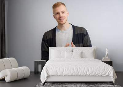 Studio portrait concept of a smiling young man talking on a white background. Wall mural