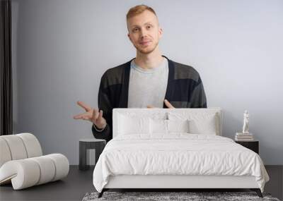 Studio portrait concept of a smiling young man talking on a white background. Wall mural