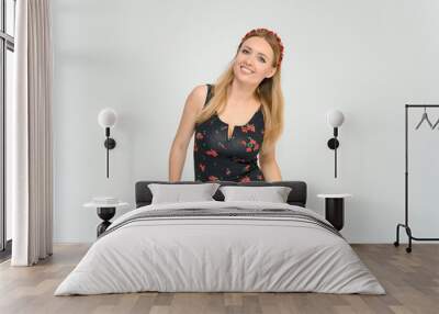 Studio portrait portrait of a pretty young happy blonde woman in a beautiful dress on a white background. He smiles, talks, shows with his hands, moves, shows emotions. Wall mural