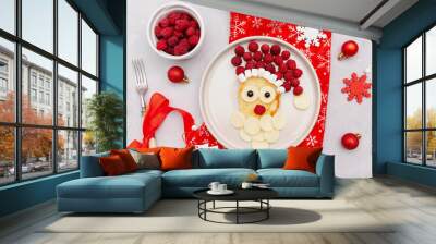 Christmas Santa Claus face shaped pancake with sweet fresh raspberry berry and cheese on plate on gray background for kids baby children breakfast dinner. xmas food with new year decorations close up. Wall mural