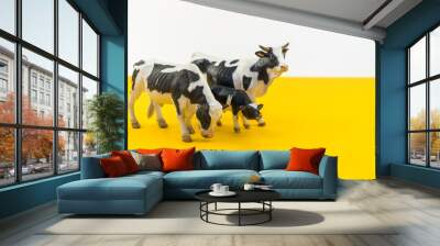 Toy cow made of plastic on a yellow background. Wall mural