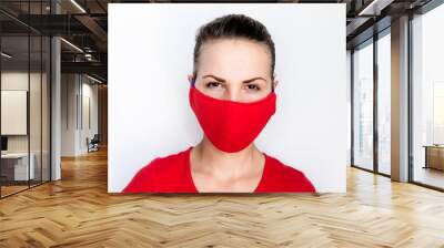 A young woman in Asian, wearing a red medical mask. A girl with a serious and angry face is looking directly at the camera. Smog protection Wall mural