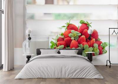 A pile of red fresh strawberries on a white plate and a cup of milk Wall mural