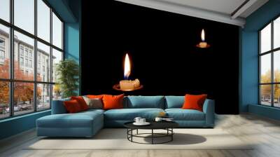 Two candles burning in the dark. The candles almost burned out. Wall mural