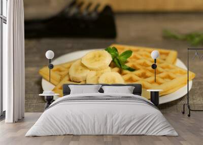 Viennese waffles with banana and mint leaf. Delicate homemade Belgian waffles on a white plate in the kitchen. Wall mural