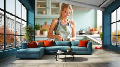 a sporty woman prepares a vegetable salad in the kitchen smiling Wall mural