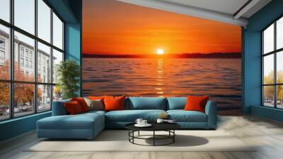 Golden sunset over calm waters reflecting warm colors in the horizon at a serene lakeside location Wall mural