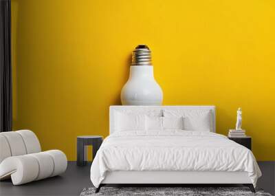 Single white lightbulb on a yellow background Wall mural