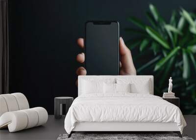 Man holding smartphone in hand, isolated on dark background Wall mural