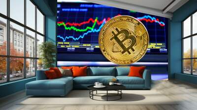 gold coin bitcoin stands edge on glass against the background of the stock chart Wall mural