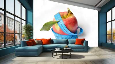 red apple and soft centimeter on a white background. diet and proper nutrition. fight against excess weight. measuring the volume of body parts Wall mural