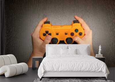 Children's hands hold the joystick from the game console Wall mural