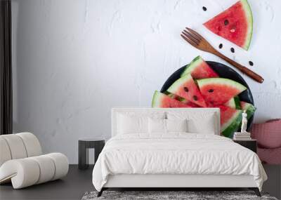 Sliced fresh watermelon in black bowl top view on white background Wall mural