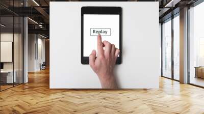 man presses a button on a tablet Replay on a white isolated background Wall mural