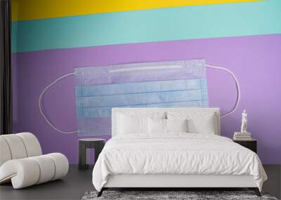 Medical mask on a colored background. Self-isolation and treatment. Diagonal layout. Wall mural