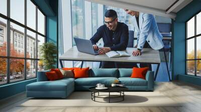 Multiethnic executive team discussing financial report while sitting at table in office. Diverse business people, businessmen planning to work together in a meeting room using a laptop computer. Wall mural