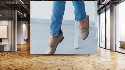 Woman's legs in trousers and beige leather shoes Wall mural