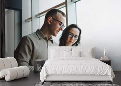 Young male and female colleagues work in a spacious office. Successful people are working on a new business project. Collective work in the office Wall mural