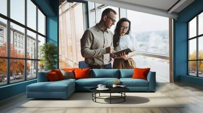 Young male and female colleagues work in a spacious office. Successful people are working on a new business project. Collective work in the office Wall mural