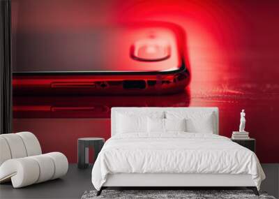 Close-Up Of A Glossy Red Smartphone On A Shiny Surface Under Dramatic Lighting Wall mural