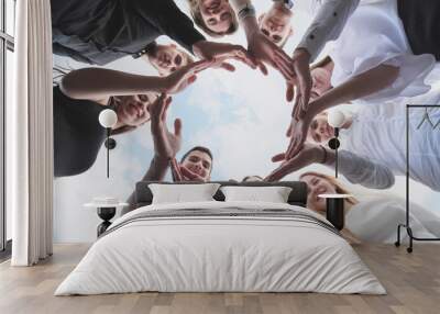 A group of high school students look through the shape of a circle created from their palms. The concept of friendly friends. Wall mural