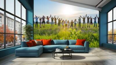 Friends are jumping holding hands at sunset. Wall mural