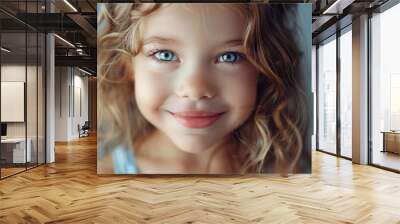 A close-up photo of a child's face with bright blue eyes, suitable for use in various contexts such as family portraits or advertising Wall mural