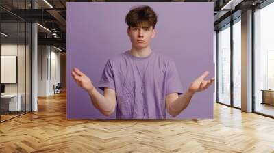 A person standing with arms extended, wearing a vibrant purple shirt Wall mural