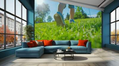 A person walking across a lush green field. Suitable for nature and outdoor themes Wall mural