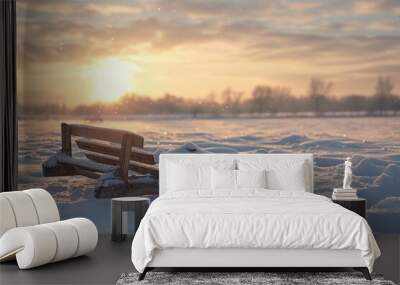 A wooden bench sits in the middle of a snowy field, surrounded by white landscape Wall mural