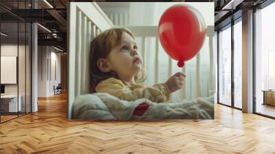 A young girl holds a bright red balloon in her hand, with a smile on her face Wall mural