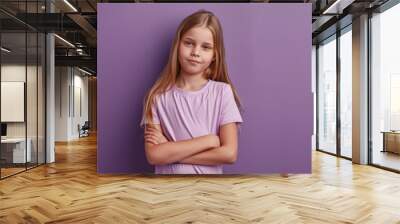 A young girl stands with her arms crossed, looking confident and independent Wall mural