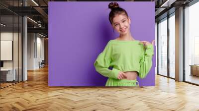 A young girl wearing a green top and shorts, possibly for outdoor activities or casual wear Wall mural