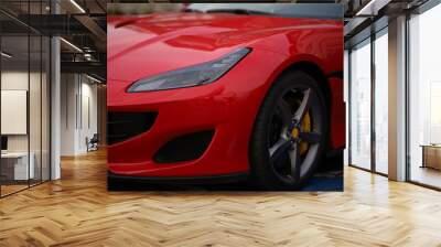 Close-up of a red sports car parked in the street. Wall mural