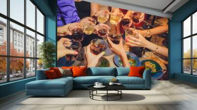 Close up shot of group of people clinking glasses with wine or champagne in front of bokeh background. older people hands. Wall mural