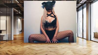 Swine mascot costume dance striptease woman in black leather pig mask. Wall mural