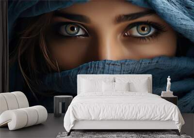 a close-up girl with beautiful eyes, wrapped in a blue scarf. Wall mural