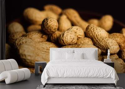 peanuts in a wooden plate on a black background Wall mural