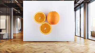 ripe oranges with sliced halves close-up on a white background Wall mural