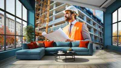 A man wearing a hard hat and orange vest is holding a blueprint Wall mural