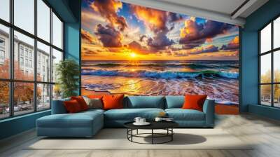 The sky is orange and the sun is setting over the ocean Wall mural