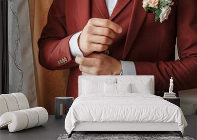 Closeup of a groom in maroon suit correcting a sleeve. Wall mural