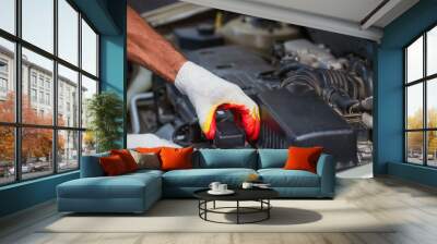 A car mechanic works in the garage. Repair. Hands of auto mechanic checking car engine at the repair garage. Car repair services Wall mural