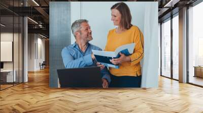 Man and woman smiling professional business people talking using laptop computer working in office. Wall mural