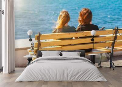 two friends sitting on a bench overlooking the sea Wall mural