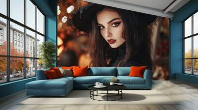 Young beautiful woman dressed as a witch for Halloween. Halloween decorated background. Wall mural