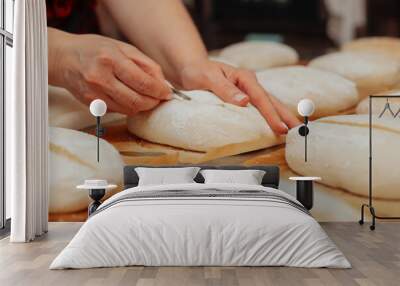 baker shaping bread raw dough before baking on the table in bakery Wall mural