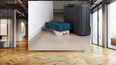 Three boxes with tools are closed. one big gray homemade master suitcase is standing, two small ones are lying in the hallway of the apartment Wall mural