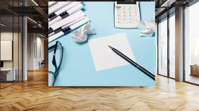 Documents, a calculator, glasses, a pen and paper lie on a light blue background. Workplace close-up. Business concept Wall mural