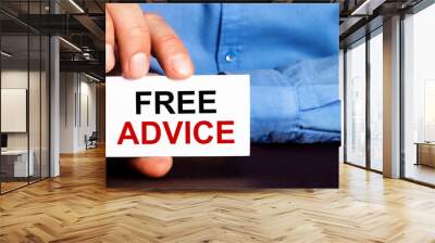 FREE ADVICE is written on a white business card in a man's hand. Advertising concept Wall mural